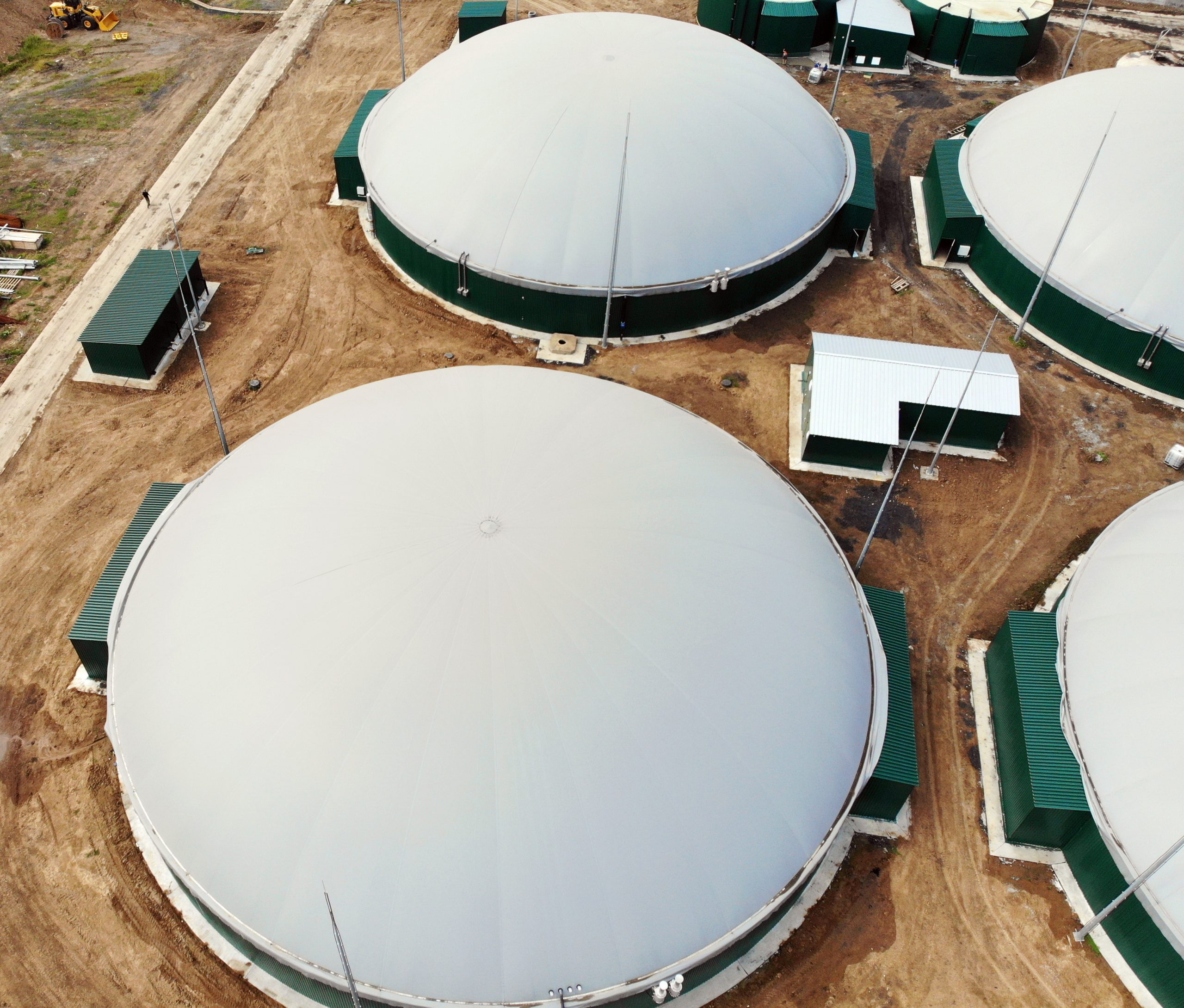 Biogas. Aerial view of a biogas plant and a farm in green fields. Renewable energy from biomass. Modern agriculture in Ukraine and the European Union. selective focus